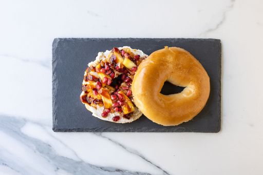A top view of an open cut bagel with delicious meat, vegetables, and sauce
