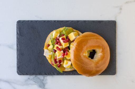 A top view of an open cut bagel with delicious meat, vegetables, and sauce