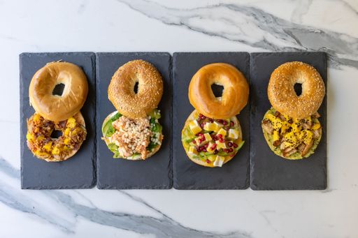 A closeup shot of open cut bagels with delicious meat, vegetables, and sauce