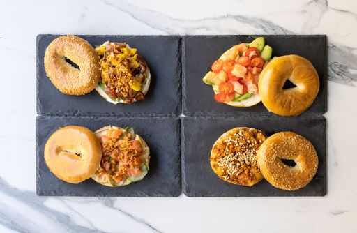 A top view of cut bagels with different gourmet toppings