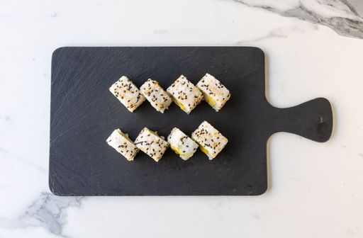 A top view of delicious gourmet inside-out sushi rolls on a wooden board