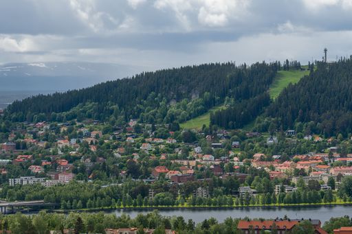A High Angle shot of the city near to lake and mountains in the background
