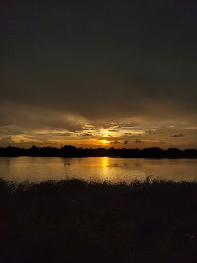 A vertical shot of the sunset reflecting in the lake