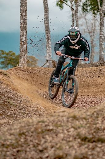 A man driving his bicycle in the forest