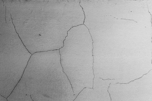 A closeup shot of cracks on a rough concrete wall- perfect for a grunge background