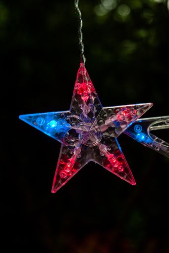 A vertical shot of glowing lights in the shape of stars for Christmas decoration