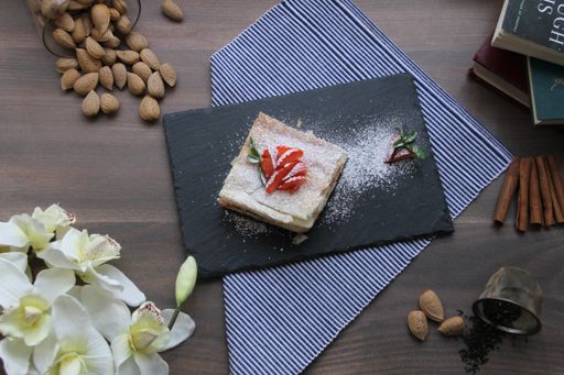 A top view of a cake with sugar powder and strawberries