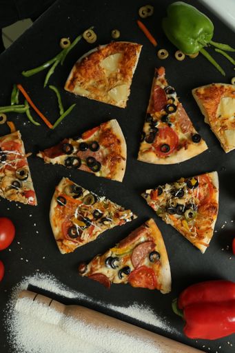 A vertical top view of different pizza slices with black background