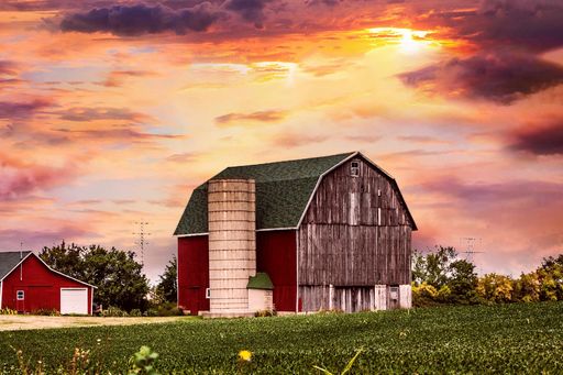 A beautiful shot of a barn on the field in the sunset