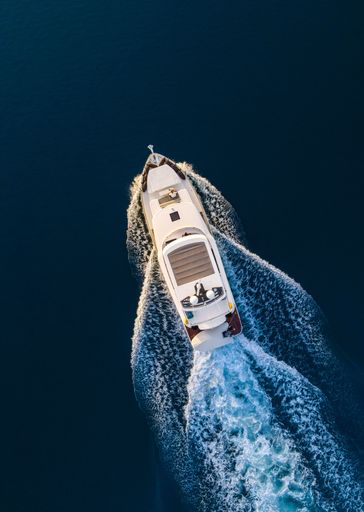 A bird-eye shot of a beautiful big yacht at cruising speed
