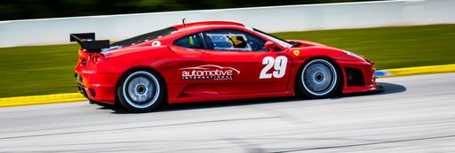 A Panoramic Shot of a car racing around the track on race day