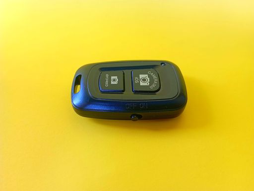 A top view of a car key with remote control in the yellow background