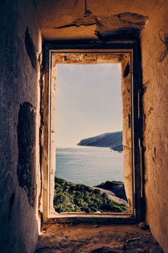 A vertical shot of a view to the sea from an abandoned building
