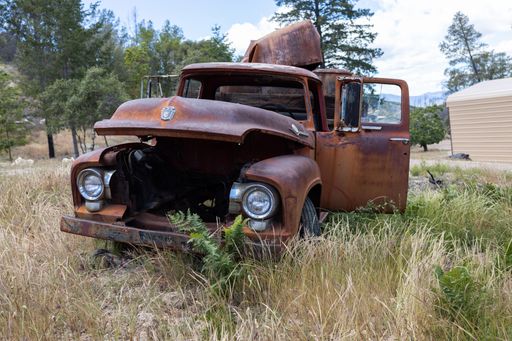 The old ruined Ford truck in the field, close-up