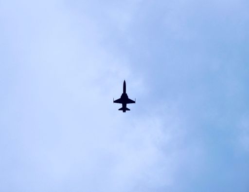 A low angle shot of an airplane flying under a blue sky