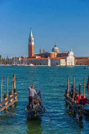 A vertical shot of a man on a boat and the St Mark's Square on the background