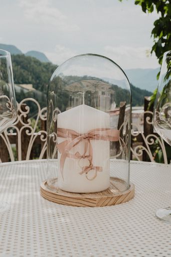A vertical shot of wedding rings with a glass cover on a table