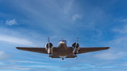 An Amelia Earhart's airplane Lockheed Electra in flight in background of blue sky