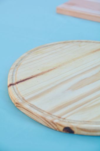 A vertical shot of round wooden chopping board