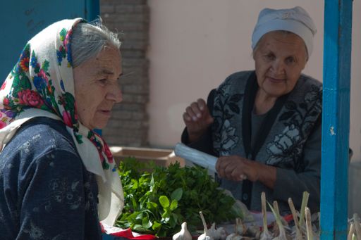 two old women buying green vegetables in the street, daily lifestyle
