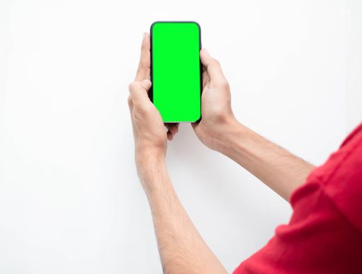 A man taking a photo with his cell phone with chromakey greenscreen