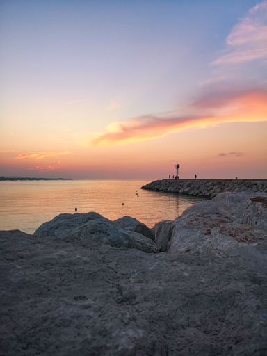 A vertical shot of a pink sunset over the coast of Senigallia, Italy