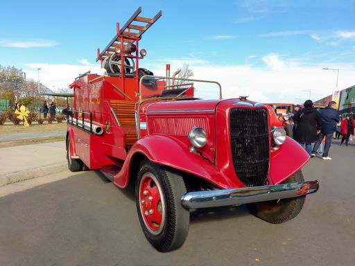 Old red 1936 Ford model 51 V8 fire truck pumper tanker. Front view. Grill. Ladder. HoseClassic car show.