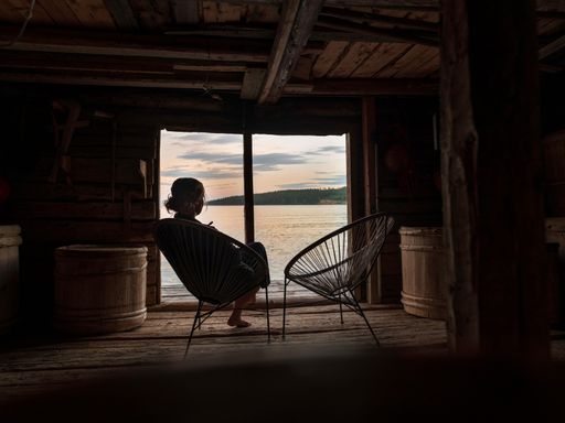A young Caucasian girl sitting on a lounge chair and admiring the view from a window
