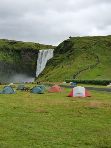 A scenic vertical shot of a campground by a waterfall in Skogar Campsite in Iceland