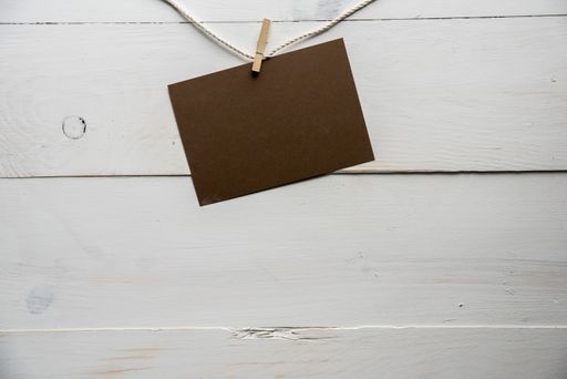 A closeup shot of an empty sign with a white wooden background - great for writing a text