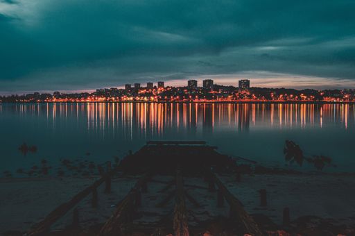 A beautiful shot of a city in lights at night from the lake
