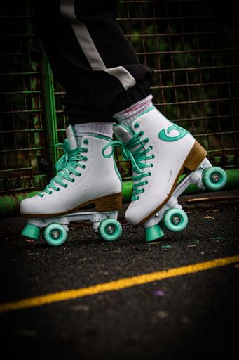 A vertical shot of a person wearing a pair of roller skates shoes on a street