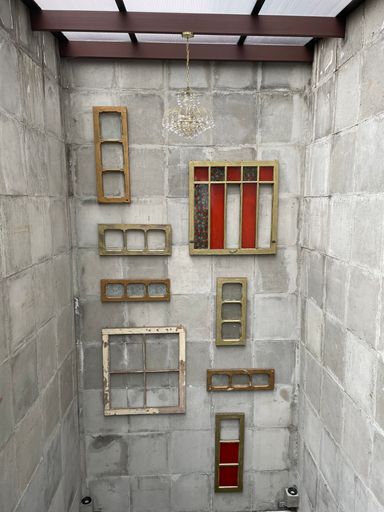 A vertical shot of different frames and borders on a wall