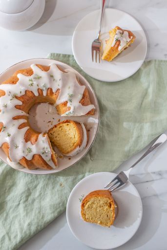 A sliced vanilla bundt cake on a white plate with forks