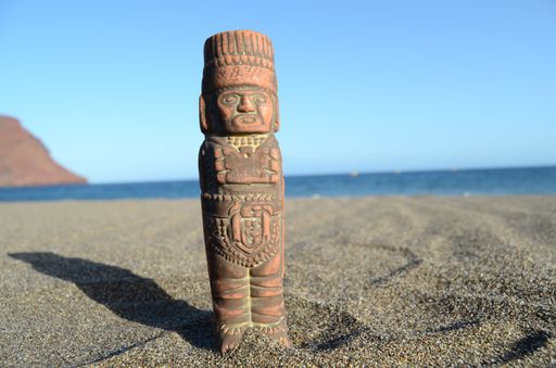 Ancient Maya Statue on the Sand Beach near the Ocean