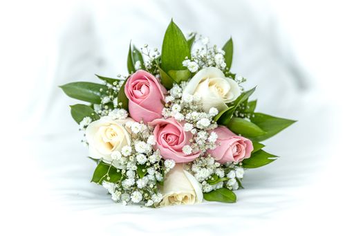 A closeup of a beautiful wedding bouquet of white and pink roses.