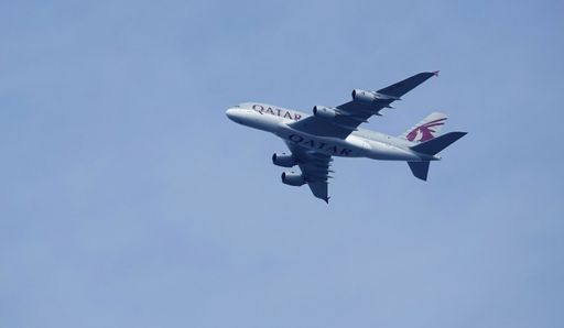 A low-angle shot of a Qatar Airways airplane flying over Billericay town in England