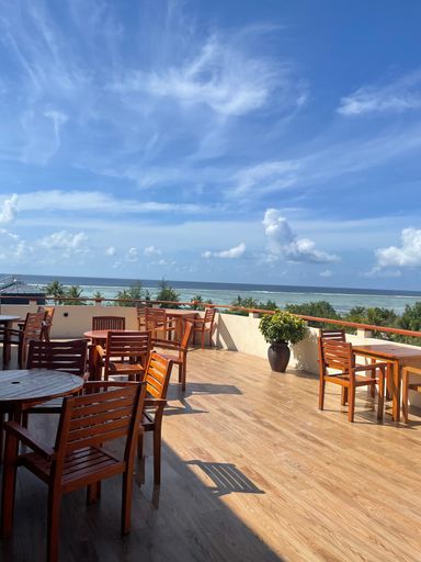 A vertical shot of a terrace with chairs and a sea view