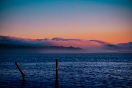 The ocean under a beautiful purple and orange sunset with clouds
