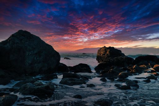 A breathtaking view of giant stones on the shore against dramatic evening sky