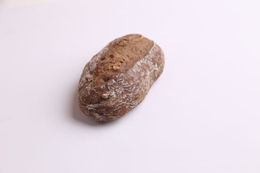 A high angle shot of black bread on a monochrome background