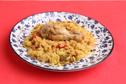 A closeup shot of delicious boiled rice with chicken on a red background
