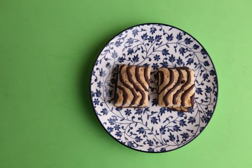 A top view of two delicious biscuits on a floral-patterned china plate, on a green surface
