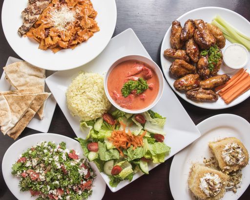 A high angle shot of a table with different food, rice, bread, salad and chicken