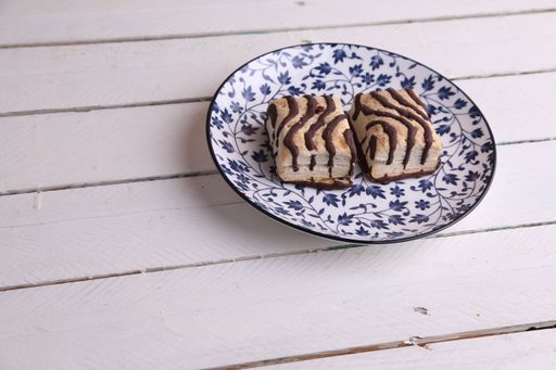 A closeup shot of delicious chocolate cake pieces in a plate on a wooden surface