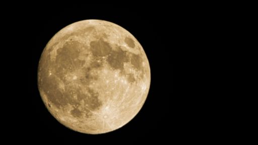 A closeup shot of the full moon on the dark black sky with a copy space