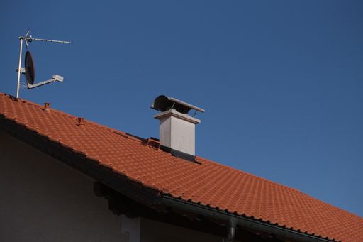 A low angle shot of a chimney against a clear blue sky