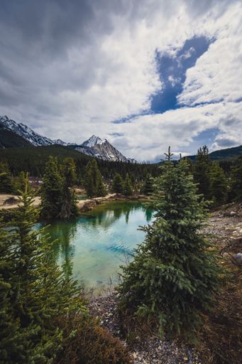 A vertical shot of Lake Braies under a cloudy sky in South Tyrol, Italy