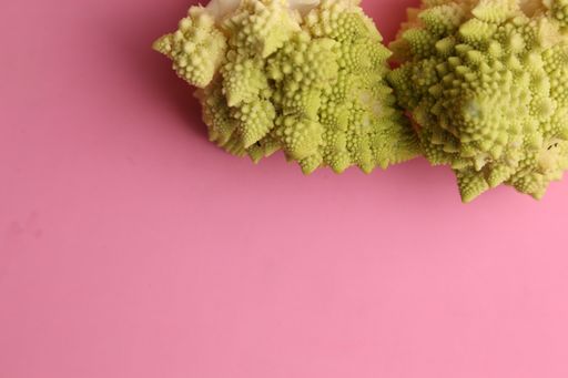 A high angle shot of some fresh broccoli isolated on a pink surface