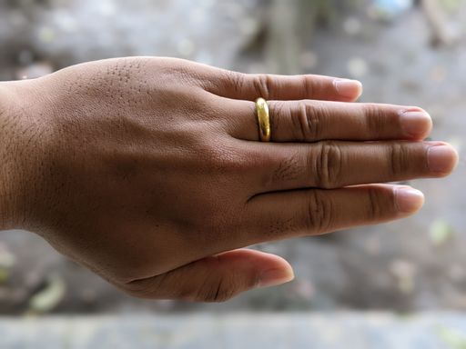 A Caucasian hand with a golden wedding ring